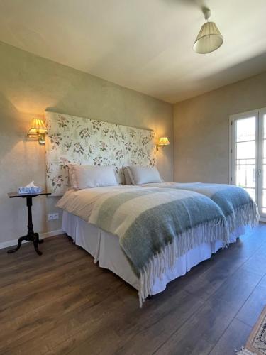 - une chambre avec un grand lit et une tête de lit fleurie dans l'établissement La Petite Maison, à Lagardère