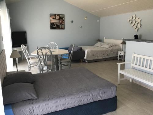 - une chambre avec un lit, une table et un lit dans l'établissement La petite girardiere, à Talmont-Saint-Hilaire