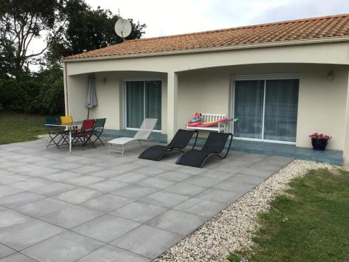 un patio avec des chaises et une table devant une maison dans l'établissement La petite girardiere, à Talmont-Saint-Hilaire