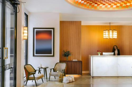 a lobby with two chairs and a reception desk at Atala Hotel Champs Elysées, Sonder by Marriott Bonvoy in Paris