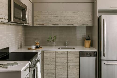 a kitchen with white cabinets and a sink at Sonder by Marriott Bonvoy The Liberty Apartments Liberty Village in Toronto