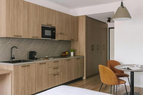 a kitchen with wooden cabinets and a table with chairs at Sonder by Marriott Bonvoy Atelier Apartments Porta Romana in Milan