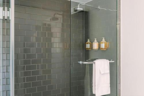 a shower with a glass door with towels and bottles at Sonder by Marriott Bonvoy Artesa Apartments West Queen West in Toronto