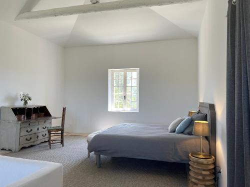 a bedroom with a bed and a dresser and a window at Bastide du Luberon in Apt