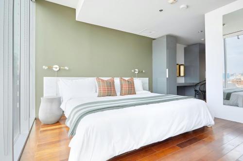 a white bedroom with a large white bed with pillows at The Slate Hotel Downtown, Sonder by Marriott Bonvoy in Toronto