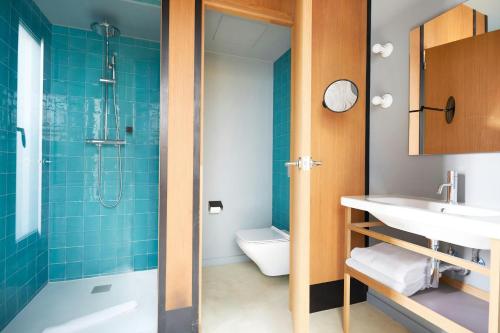 a bathroom with a shower and a sink and a toilet at Le Palacete Hotel Gracia District, Sonder by Marriott Bonvoy in Barcelona