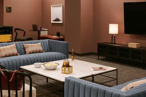 a living room with couches and a table and a television at Sonder by Marriott Bonvoy Arlo Apartments Downtown in Ottawa