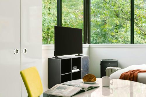 a living room with a tv and a table at Sonder by Marriott Bonvoy Revival Apartments English Bay in Vancouver