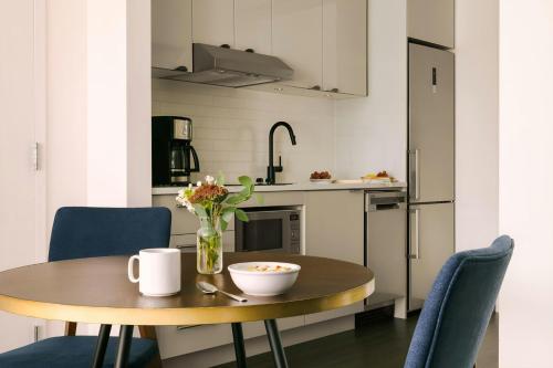 a small kitchen with a wooden table and blue chairs at Sonder by Marriott Bonvoy Revival Apartments English Bay in Vancouver