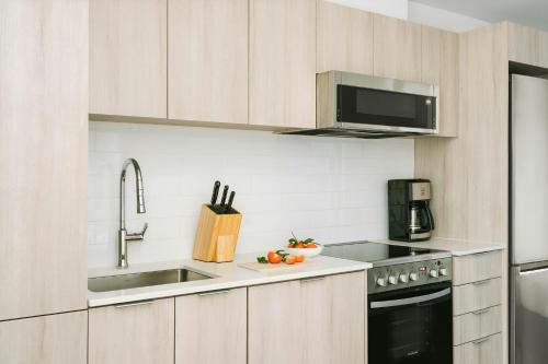 a kitchen with a sink and a microwave at Sonder by Marriott Bonvoy Le Guerin Apartments Le Plateau-Mont-Royal in Montréal