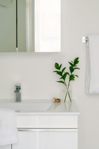 a bathroom with a white sink with a plant on it at Sonder by Marriott Bonvoy Le Guerin Apartments Le Plateau-Mont-Royal in Montréal