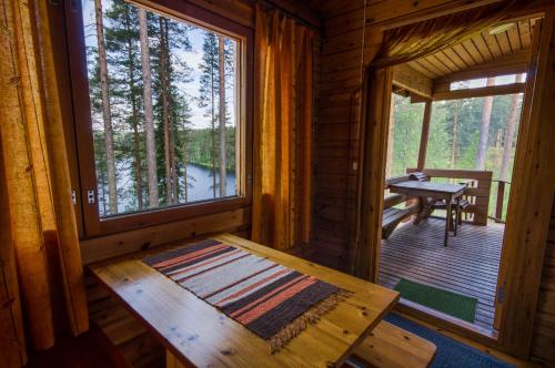 Holzhütte mit einem Tisch und einem Fenster in der Unterkunft Ahvenlampi Camping in Saarijärvi