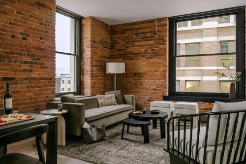 a living room with a couch and a brick wall at Sonder by Marriott Bonvoy Apollon Apartments Old Montreal in Montréal