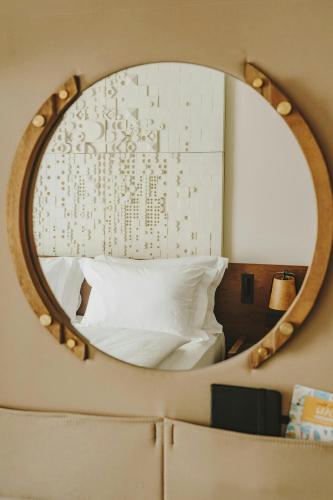 a mirror on a wall with a bed in a room at Casa Luz Hotel Plaça Universitat, Sonder by Marriott Bonvoy in Barcelona