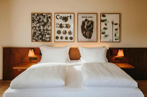 two white beds in a room with pictures on the wall at Casa Luz Hotel Plaça Universitat, Sonder by Marriott Bonvoy in Barcelona