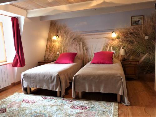 deux lits dans une chambre avec des oreillers rouges dans l'établissement Demeure des tilleuls, à Locquénolé
