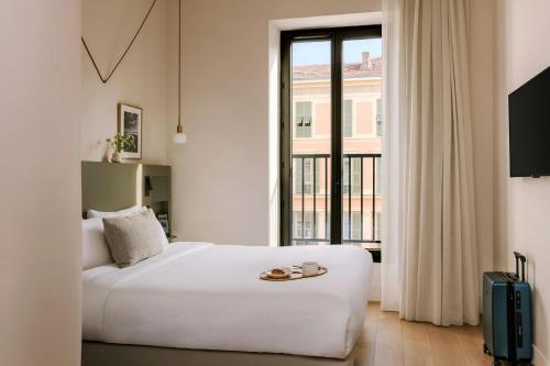 a bedroom with a white bed and a large window at Yelo Jean Médecin Hotel, Sonder by Marriott Bonvoy in Nice