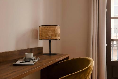 a desk with a lamp and a cup on it at Los Arcos Hotel Gothic Quarter, Sonder by Marriott Bonvoy in Barcelona