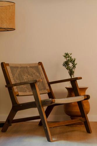 a wooden chair with a potted plant sitting next to a table at Los Arcos Hotel Gothic Quarter, Sonder by Marriott Bonvoy in Barcelona