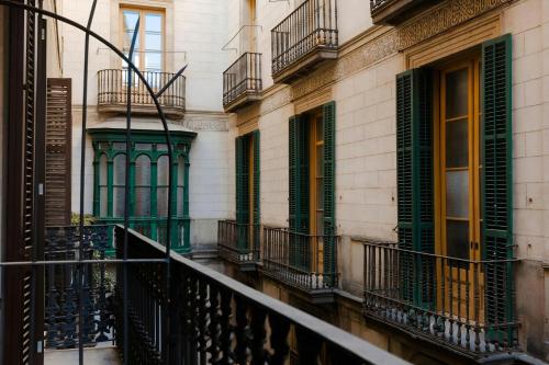 a balcony of a building with green doors and windows at Los Arcos Hotel Gothic Quarter, Sonder by Marriott Bonvoy in Barcelona