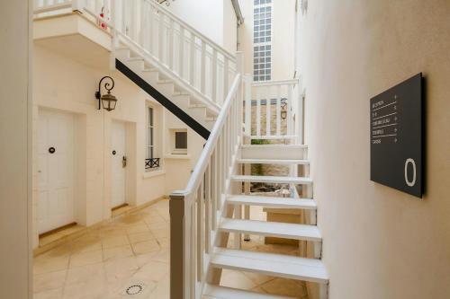 Una escalera en una casa con un cartel de escalera en la pared. en Quintinie Hotel 15th Arrondissement, Sonder by Marriott Bonvoy, en París