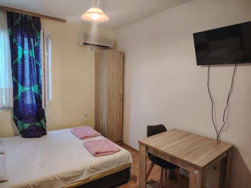 a small room with a bed and a desk and a television at Studio apartmani Dream Iv in Šušanj