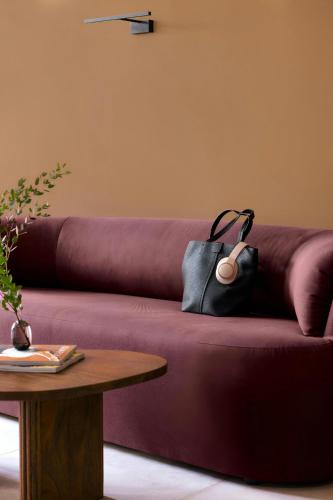 a purple couch with a black purse sitting on it at Yvette Hotel Porte de Versailles, Sonder by Marriott Bonvoy in Vanves