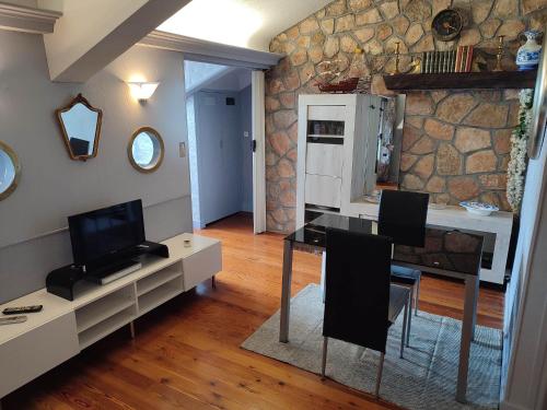 - un salon avec une table à manger et un mur en pierre dans l'établissement Appartement Riviera Palace, à Menton