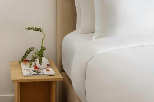 a bedroom with a bed and a side table with a bed at Yvette Hotel Porte de Versailles, Sonder by Marriott Bonvoy in Vanves