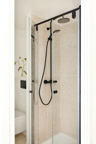 a shower with a glass door in a bathroom at Yvette Hotel Porte de Versailles, Sonder by Marriott Bonvoy in Vanves