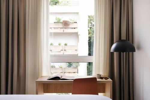 a bedroom with a desk in front of a window at Yvette Hotel Porte de Versailles, Sonder by Marriott Bonvoy in Vanves