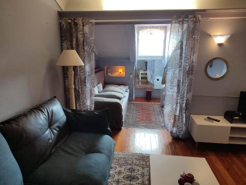 un salon avec un canapé et un salon avec une fenêtre dans l'établissement Appartement Riviera Palace, à Menton