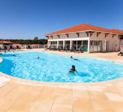 un groupe de personnes nageant dans une piscine dans l'établissement Ideal famille - piscine intérieur chauffée et extérieure, à Cassen