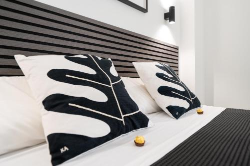 a bedroom with a bed with black and white pillows at Las Flores Luxury Apartment in Málaga