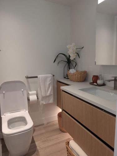 a bathroom with a white toilet and a sink at Executive Studio in Vancouver