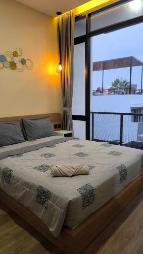 a bedroom with a large bed with a large window at Villa Panderman Batu Malang in Batu