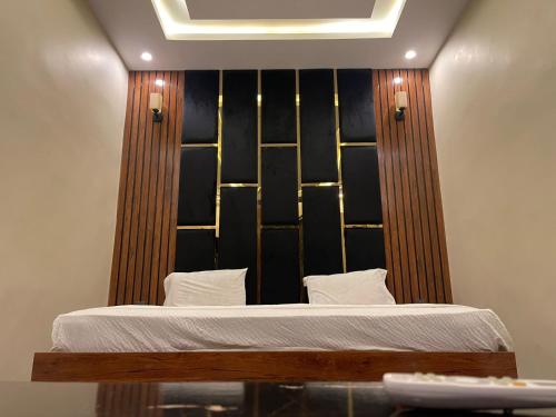 a bed with a wooden headboard in a room at Elegant Guest House Karachi in Karachi