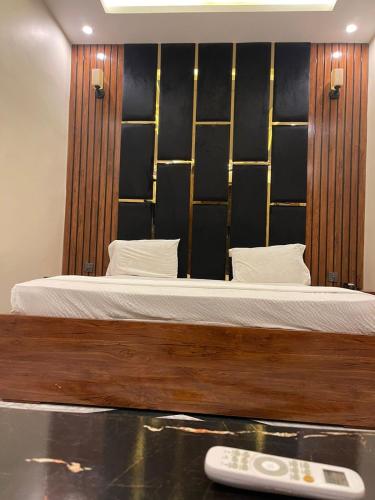 a bedroom with a bed and a remote control at Elegant Guest House Karachi in Karachi