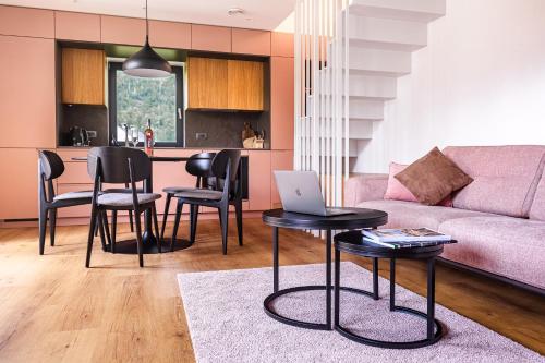 a living room with a couch and a table with a laptop at Vila Nina Bohinj in Bohinj
