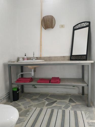 a bathroom with a bench with a mirror and a sink at Zina Resort Guesthouse & Camping in Zurayq Barrānīyah