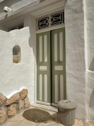 a green door on a white house with a toilet at ZINA RESORT camping touristique in Zurayq Barrānīyah