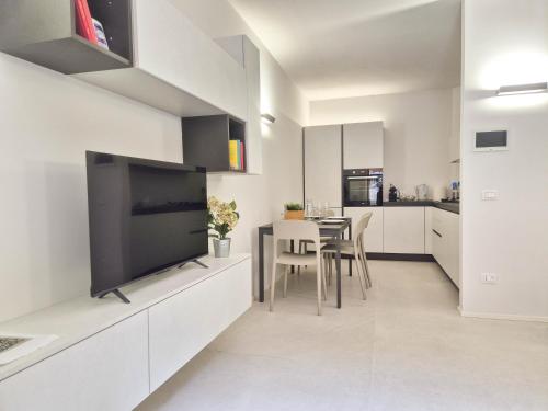 a kitchen and dining room with a large flat screen tv at Piazzetta Signori By Case al Lago in Desenzano del Garda