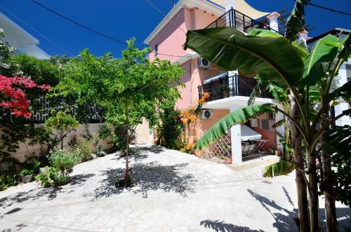 a pink house with a tree in front of it at Villa Ektoras II by EY Villas in Parga