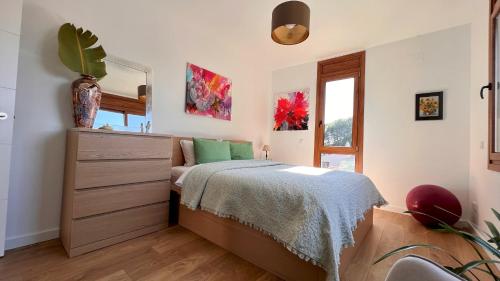 une chambre avec un lit, une commode et un miroir dans l'établissement Casa Tres Cales, à L'Ametlla de Mar