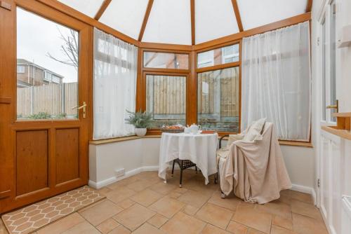 a conservatory with a table in a room with windows at Capstone in Swanage