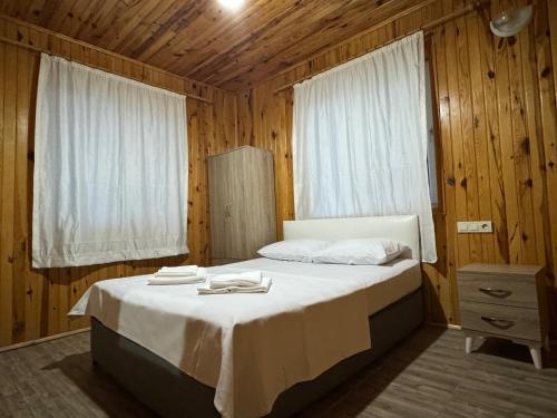 a bedroom with a bed with two towels on it at Atlas Bungalows in Kumluca