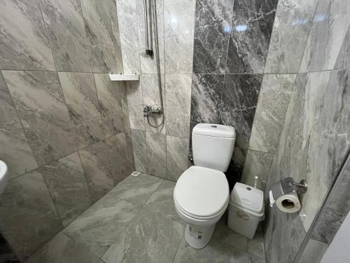 a bathroom with a white toilet and a sink at Atlas Bungalows in Kumluca