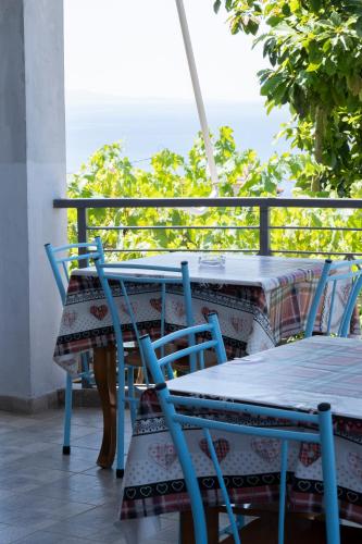 a table and chairs on a balcony with a view of the ocean at Dagos Rooms in Dhërmi