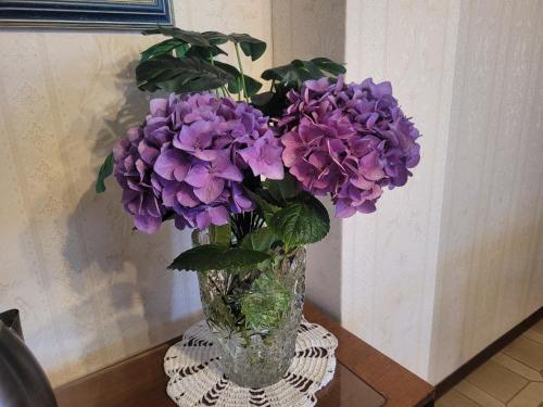 a vase filled with purple flowers on a table at Bella Vista Lago Como in Bellano