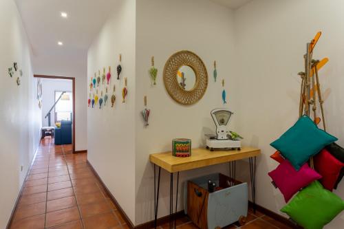 a hallway with a table and a mirror on the wall at WHAT a fish in Praia da Vagueira
